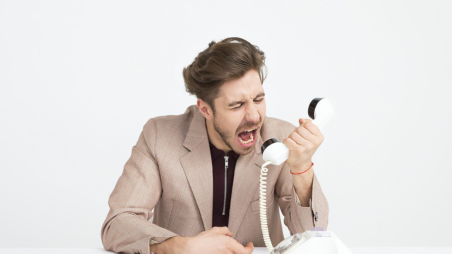 man holding telephone screaming